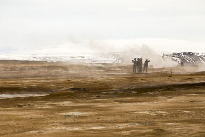 People standing on landscape against sky