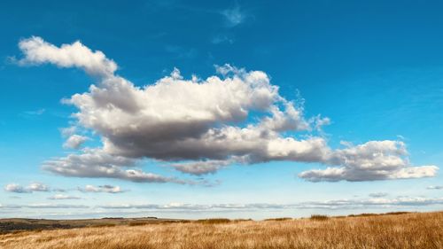 Scenic view of land against blue sky