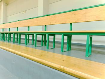 Empty chairs against wall in building