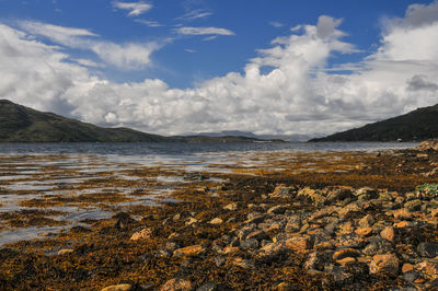 Scenic view of sea and mountains against sky