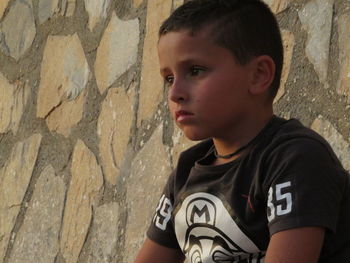 Portrait of boy standing against wall