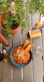 Tasty lamb meat spaghetti pasta on wooden table at outdoor restaurant