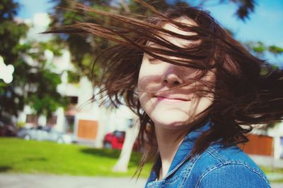 Close-up of young woman tossing hair