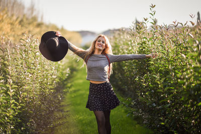 Smiling woman standing amidst plants