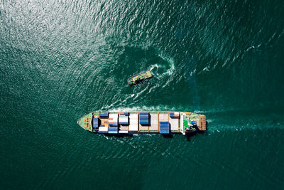 Container ship sailing on the green sea full speed container for logistics, import export, business 