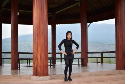 Full length portrait of young woman standing in gazebo