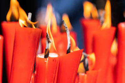 Rows of burning red candles are used in religious prayers