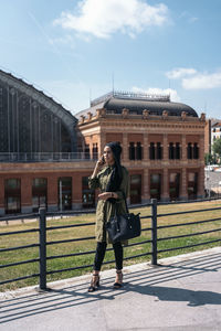 Rear view of woman standing against built structures