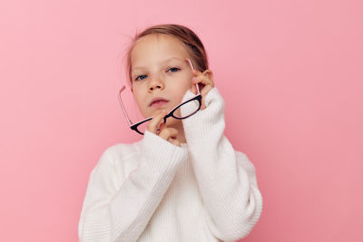Portrait of cute girl with stethoscope against pink background