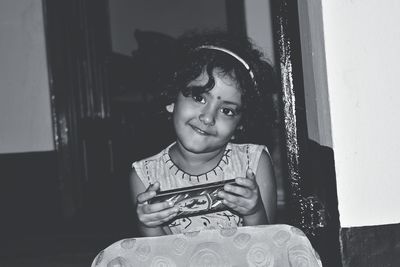 Portrait of smiling girl sitting at home