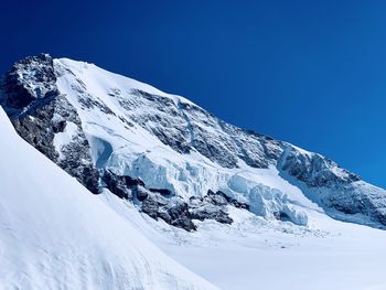 Scenic view of snowcapped mountains against clear blue sky