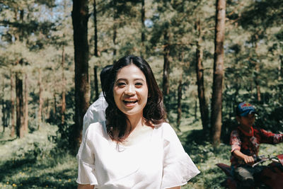 Portrait of a smiling young woman in forest