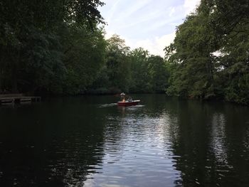 Boats in river with trees in background