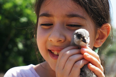Close-up of happy girl holding bird