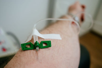 Cropped hand of man with iv drip at hospital