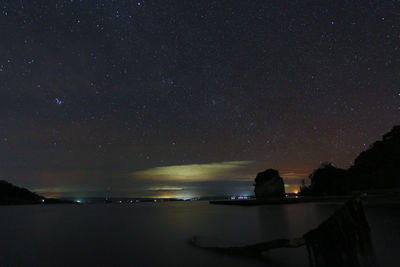 Scenic view of sea against star field at night