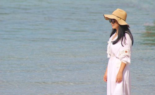 Woman wearing hat standing at beach