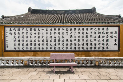 Bench against information sign on building 