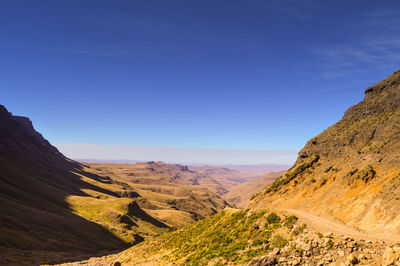 Scenic view of rocky mountains against clear blue sky