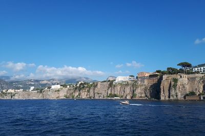 Scenic view of sorrento and the seaside against blue sky.