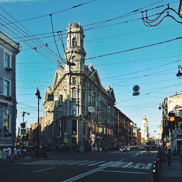 building exterior, architecture, built structure, power line, transportation, street, car, cable, city, road, electricity pylon, land vehicle, sky, mode of transport, city street, city life, electricity, clear sky, street light, power supply