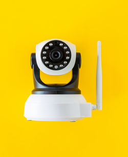 High angle view of camera against yellow background