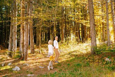 Rear view of couple walking in forest