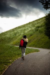 Rear view of woman walking on road