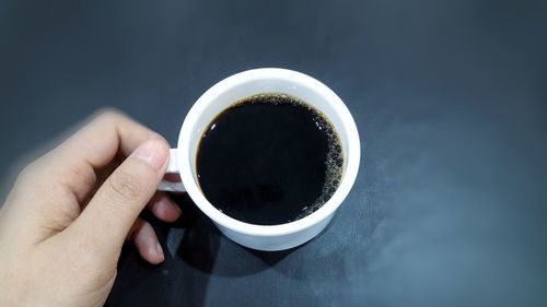 Cropped image of hand holding coffee cup