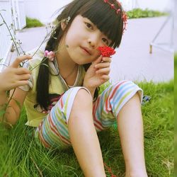 Portrait of smiling young woman sitting in park