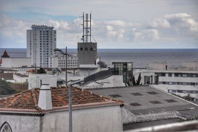 View of city by sea against sky