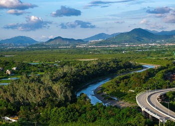 High angle view of a s-shape road and river against blue sky