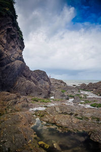 Rock formations by sea against sky