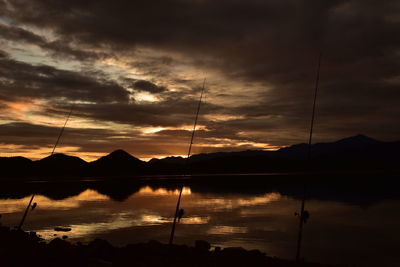 Scenic view of lake against dramatic sky during sunset