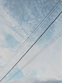 Low angle view of power lines against sky