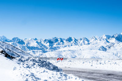Scenic view of snowcapped mountains against clear blue sky