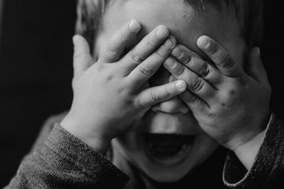 Close-up portrait of a man covering face with hand