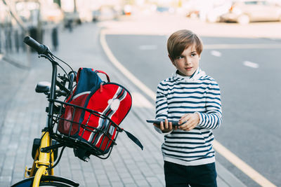 Portrait of boy standing on motorcycle