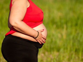 Midsection of woman touching red outdoors