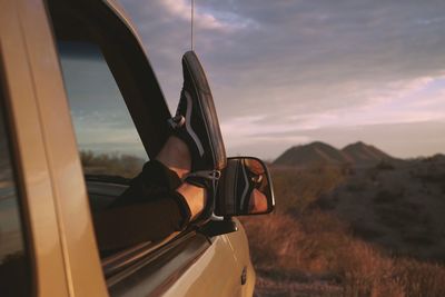 Close-up of motorcycle against sky at sunset