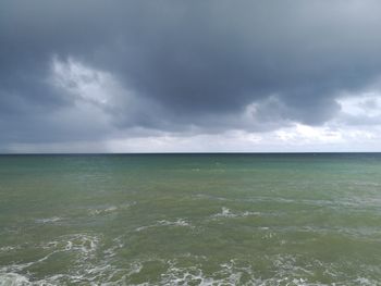 Scenic view of sea against storm clouds