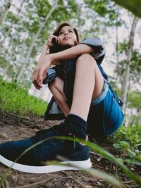 Full length of young woman sitting on field