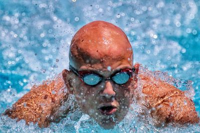 Close-up of a young man swimming in pool