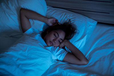 High angle view of woman sleeping on bed