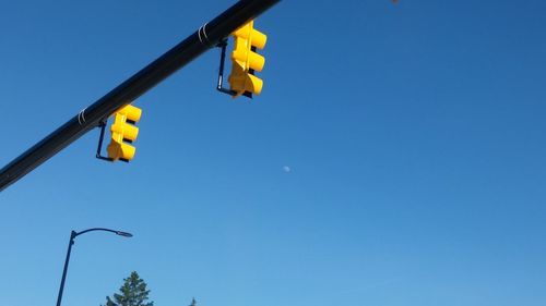 Low angle view of road signal against clear blue sky