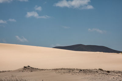 Scenic view of desert against cloudy sky