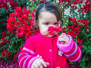 Portrait of cute girl holding pink flower