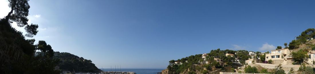 Panoramic view of sea against clear blue sky