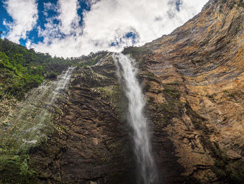 Scenic view of waterfall against sky