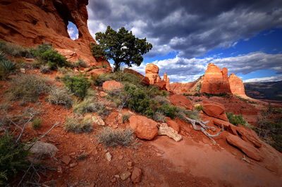 Low angle view of rock formation against cloudy sky